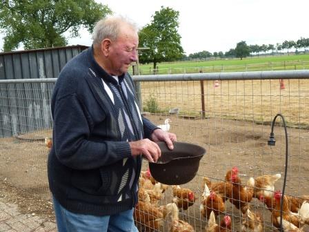 Bestand:Theet Tiggelovend voert kippen.jpg