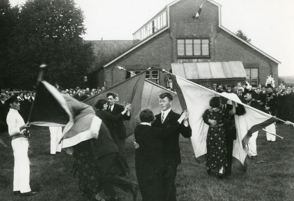 Bestand:Vendelzwaaien Beek, Paartjes, pas getrouwd of die op het punt stonden te gaan trouwen, moesten onder het vendel door v.l.n.r.. Echtpaar 1 onbekend, echtpaar 2 Joseph en Riek Westerhof Gerritsen getrouwd,.png